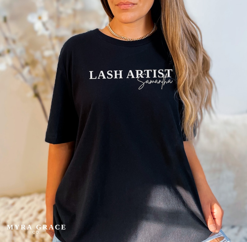 Pu&ograve; includere: T-shirt nero con la scritta bianca "LASH ARTIST Samantha". La maglietta ha maniche corte e girocollo. Il marchio "MYRA GRACE CO." &egrave; stampato in basso a sinistra.