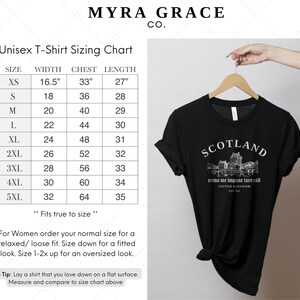 May include: Black unisex t-shirt with rolled-up sleeves, featuring the word "SCOTLAND" above a graphic of a castle and the text "nemo me impune lacessit" and "UNITED KINGDOM EST. 1543". A sizing chart is also visible.