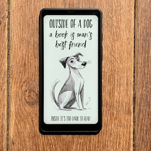 May include: A black smartphone displays a black and white illustration of a dog with the text "OUTSIDE OF A DOG a book is man's best friend INSIDE IT'S TOO DARK TO READ". The phone is on a wooden surface.