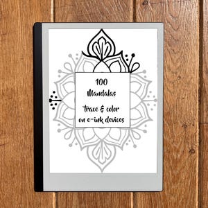 May include: A digital e-ink device displaying a mandala design with the text "100 Mandalas trace & color on e-ink devices." The device is black and gray, set against a wooden background.