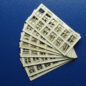 Può includere: Un set di dieci vetri per finestre in legno tagliati al laser, ognuno con un design diverso. I vetri sono disposti a ventaglio e sono realizzati in Gran Bretagna. Il testo sul vetro superiore recita "© CUT crafts K-3001c Made in Britain".