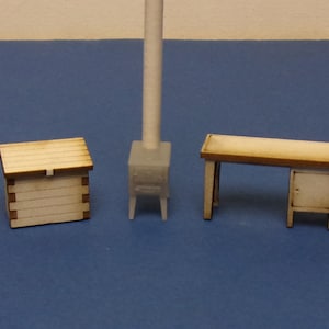 Pode incluir: Conjunto de móveis de madeira em miniatura, incluindo uma cômoda, um baú, um fogão, uma escrivaninha e uma cadeira. As peças são marrons claras com grão de madeira visível, dispostas sobre uma superfície azul. A cômoda tem quatro gavetas.