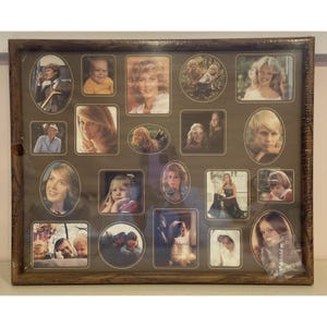 May include: A rectangular wooden picture frame containing a collage of seventeen individual photographs of various people, including portraits and group shots in oval, square, and rectangular formats, all arranged on a dark brown background.