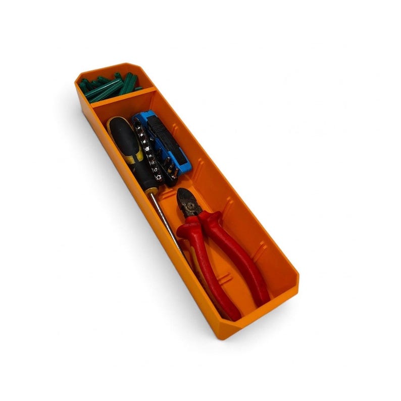 May include: An orange rectangular plastic storage tray with two compartments. The smaller top section holds green wall anchors, while the larger bottom section contains a screwdriver, a blue multi-bit tool, and red-handled wire cutters.