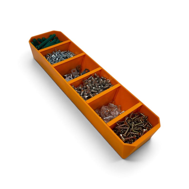 May include: An orange plastic storage tray with five rectangular compartments. The tray is filled with various hardware items, including green plastic wall anchors, silver metal screws, small metal brackets, and gold-colored wood screws.
