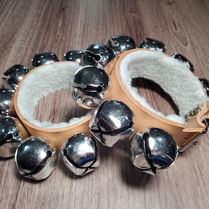 May include: A white ceramic mug with a black handle and the text "But First, Coffee" in a bold, black font. The mug is set against a blurred background, suggesting a cozy setting. The mug appears to be approximately 4 inches tall.