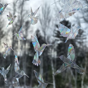 May include: A collection of iridescent hummingbird window clings, each with a unique mosaic pattern. The clings are made of a clear, durable material and are designed to add a touch of whimsy to any window.