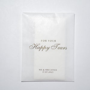 Pu&ograve; includere: Busta in carta velina bianca con scritta dorata "For Your Happy Tears" e "Mr & Mrs Jones 17.07.2023".
