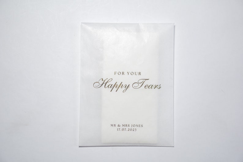 Pu&ograve; includere: Busta in carta velina bianca con scritta dorata "For Your Happy Tears" e "Mr & Mrs Jones 17.07.2023".