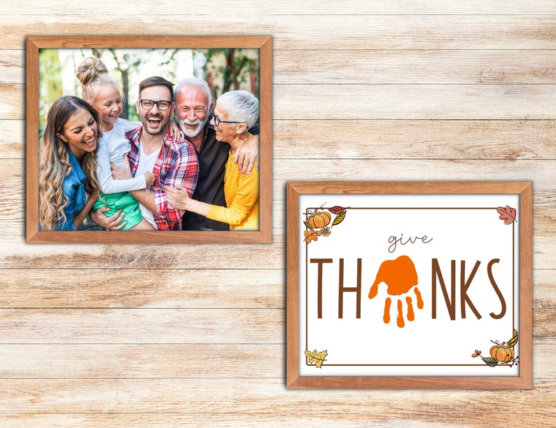 May include: A framed photograph of a family of four smiling and laughing together. The photo is in a brown wooden frame. Below the photo is a framed print with the words "give THANKS" in brown lettering with an orange handprint in the middle. The print is also in a brown wooden frame.