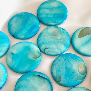 May include: A collection of round, blue and white shell-like discs. The discs have a marbled pattern and a smooth, glossy finish.