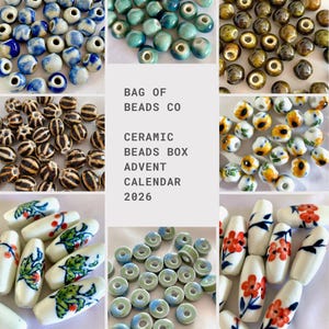 May include: A collection of ceramic beads in various shapes and patterns, including blue and white, teal, brown, striped, sunflower, and floral designs. The center text reads: BAG OF BEADS CO CERAMIC BEADS BOX ADVENT CALENDAR 2026.
