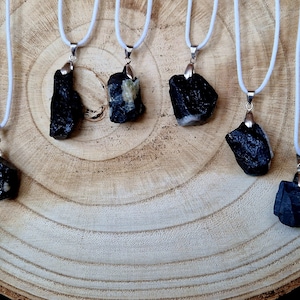Rough tourmaline pendant on a white cotton cord