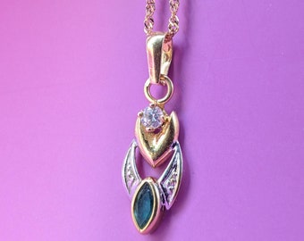 May include: A gold chain necklace with a pendant featuring a green gemstone, a white stone, and gold accents.