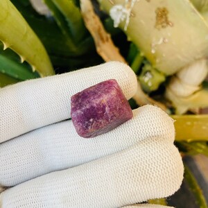 Peut inclure: Une pierre précieuse carrée de couleur violet foncé avec une texture brute et naturelle.