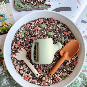 May include: A set of three ceramic mugs with a speckled, matte finish. The mugs are in shades of cream, light gray, and dark gray. Each mug has a simple, minimalist design, perfect for coffee or tea.