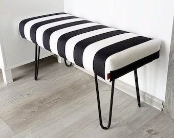 Bench with black legs for entryway, black and white footstool in a nautical living room, dressing table stool in a bedroom, end of bed seat