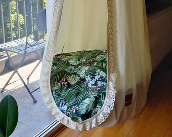 Boho hanging swing chair with a floral cushion, comortable hammock with a botanical pillow in the kids bedroom, cozy reading nook decor idea