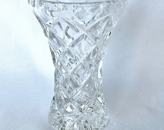 May include: A clear glass vase with a diamond pattern. The vase is tall and slender with a wide mouth.