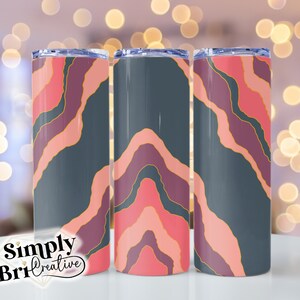May include: Three stainless steel tumblers with a colorful abstract design. The tumblers feature a pattern of pink, purple, and gold lines on a dark gray background.
