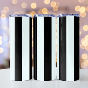 May include: Three stainless steel tumblers with black and white vertical stripes. The tumblers are on a white surface.