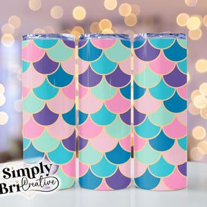 May include: Three stainless steel tumblers with a mermaid scale pattern. The tumblers are pink, blue, and purple with gold accents.