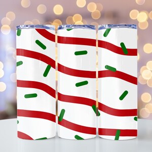 May include: Three stainless steel tumblers with a red and white candy cane stripe pattern and green sprinkles.