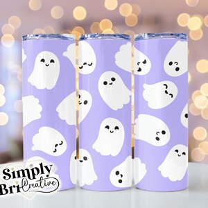 May include: Three stainless steel tumblers with a purple background and a white ghost pattern. The ghosts have different facial expressions. The tumblers are on a white surface.