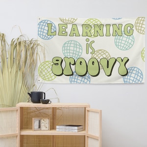 May include: A white tapestry with a green and blue pattern of circles. The text "LEARNING is GROOVY" is written in green letters.