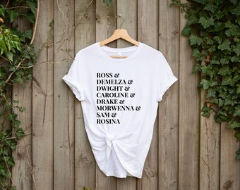 May include: White t-shirt with black text that reads "ROSS & DEMELZA & DWIGHT & CAROLINE & DRAKE & MORWENNA & SAM & ROSINA"