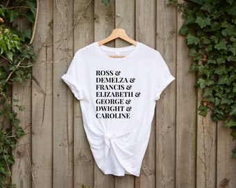 May include: White t-shirt with black text that reads "Ross & Demelza & Francis & Elizabeth & George & Dwight & Caroline"