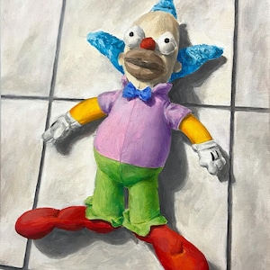 Può includere: Un pupazzo di clown di peluche con capelli blu, una camicia rosa, pantaloni verdi e scarpe rosse giace su un pavimento di piastrelle bianche.