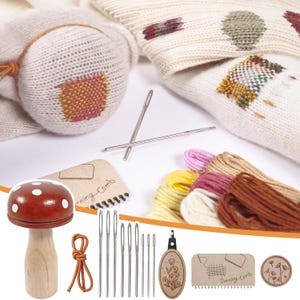 May include: A collection of craft supplies for mending and embroidery. Includes a wooden mushroom, needles, embroidery floss, a darning comb, and a wooden floral design. The background features a white knitted fabric with embroidered patches.