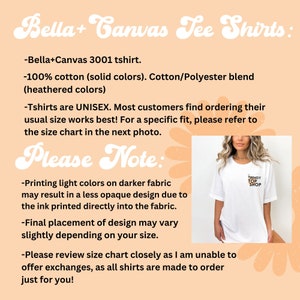 May include: A white Bella + Canvas 3001 unisex t-shirt with the text "TRENDY TOP SHOP" printed on the front. The text is in black, gold, and white. The t-shirt is on a peach background with a floral design.