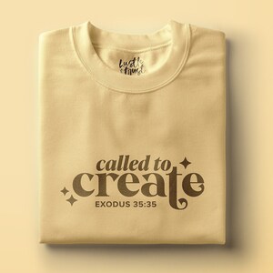 May include: A beige t-shirt with the text "called to create" in brown lettering and the text "EXODUS 35:35" below it. The shirt also has the text "hustle & trust" in black lettering near the neckline.