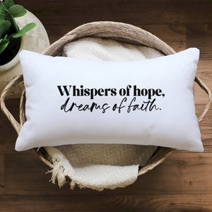 Puede incluir: Almohada blanca con texto negro que dice "Whispers of hope, dreams of faith."