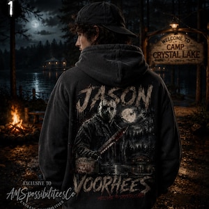 May include: A dark gray hooded sweatshirt featuring a graphic print on the back. The design depicts a hockey-masked figure holding a knife, with the text "JASON VOORHEES" in a distressed font. The scene includes a forest, a full moon, and a lake.