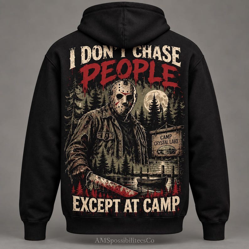 May include: A black hooded sweatshirt featuring a graphic on the back of a hockey-masked figure holding a machete. The text reads I DON'T CHASE PEOPLE EXCEPT AT CAMP. The scene includes a forest, a full moon, a boat, and a sign for CAMP CRYSTAL LAKE.