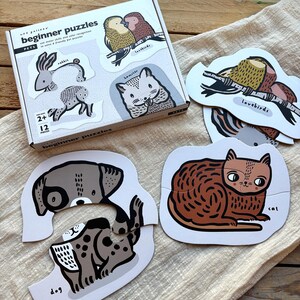 Peut inclure: Un ensemble de 12 puzzles pour débutants représentant différents animaux, dont un chien, un chat, un lapin, un hamster et des tourterelles. Les puzzles sont en carton solide et sont parfaits pour les jeunes enfants.