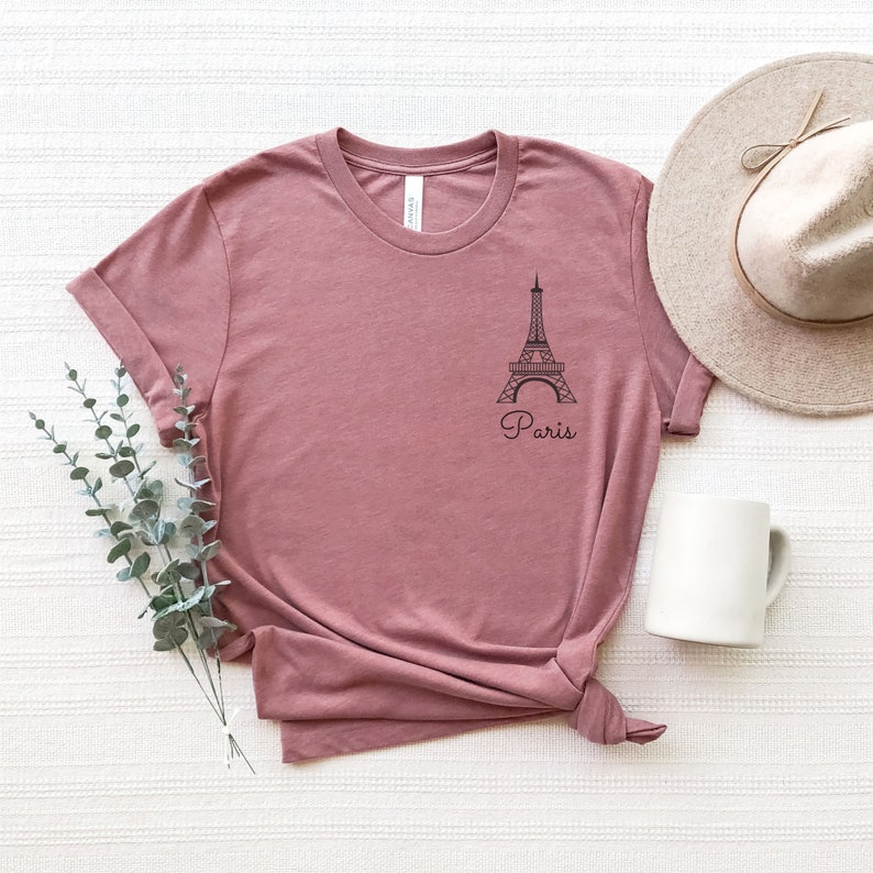 May include: A mauve t-shirt with a black outline of the Eiffel Tower and the word "Paris" printed on the front.