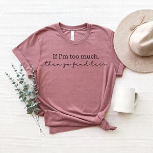 Op de afbeelding: Een mauve t-shirt met de tekst "If I'm too much, then go find less" in het zwart.