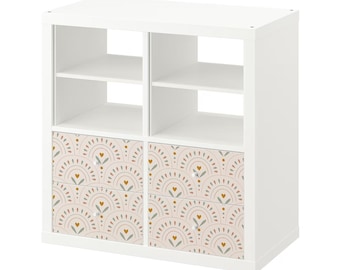 May include: White cube storage shelf with four drawers. The drawers have a pink and green geometric pattern with gold accents.