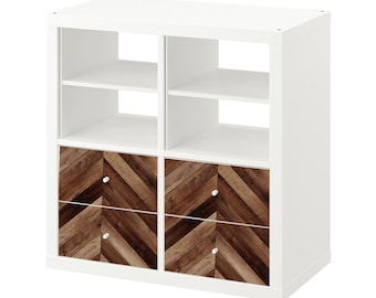 May include: White cube shelf unit with four drawers. The drawers have a woodgrain pattern with a chevron design.