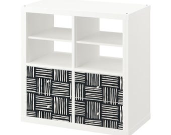 May include: White cube shelf unit with two drawers. The drawers have a black and white geometric pattern.