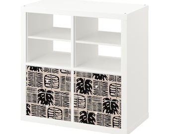 May include: White cube shelf unit with two open shelves and two drawers. The drawers are covered with a black and beige patterned fabric.