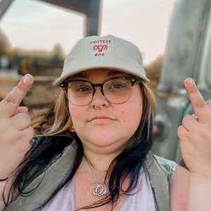 Pro Roe Reproductive Rights Baseball Hat in the color beige. Representing Abortion rights, as well as women's rights. Pro choice hat depicts embroidered uterus, reading "Pro Roe."