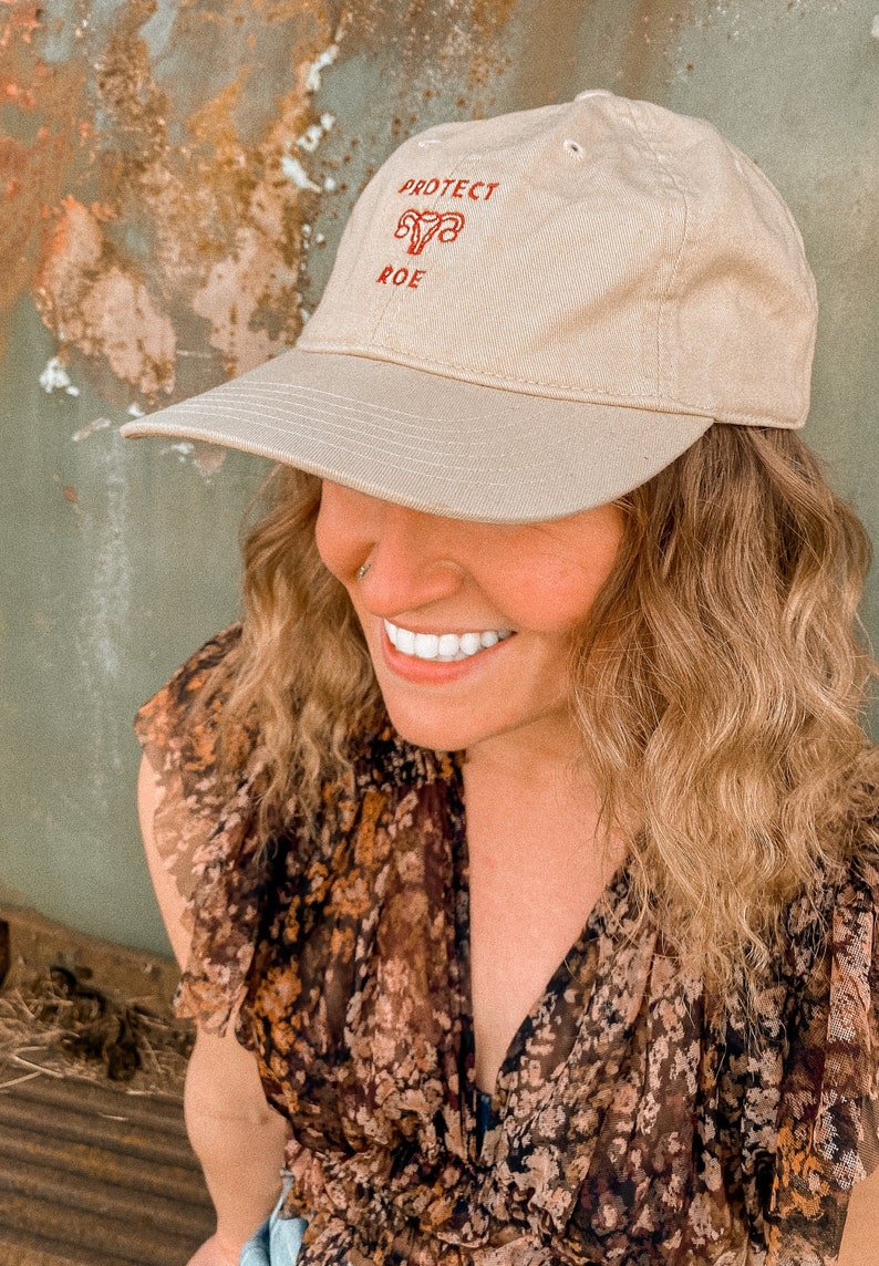 Pro Roe Reproductive Rights Dad Hat in a beige color. Representing Abortion rights, as well as women's rights to control their own body. Pro choice hat depicts embroidered uterus, reading "Pro Roe."