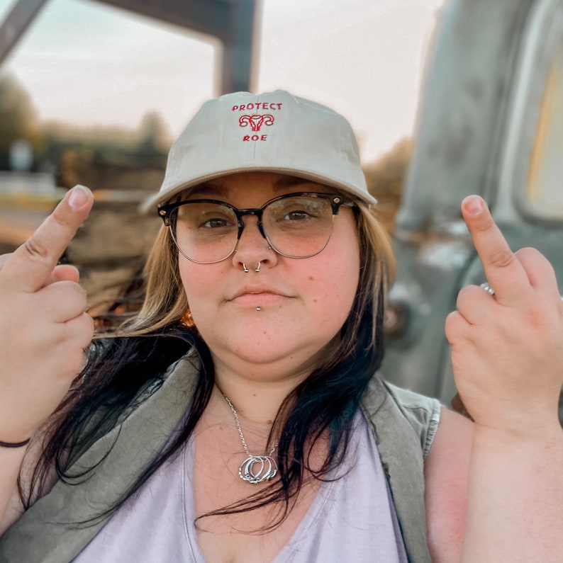 Pro Roe Reproductive Rights Baseball Hat in the color beige. Representing Abortion rights, as well as women's rights. Pro choice hat depicts embroidered uterus, reading "Pro Roe."