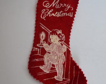 Mini calcetín navideño de fieltro vintage con estampado de Feliz Navidad, niña pequeña en las escaleras.