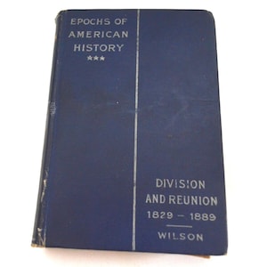 Pode incluir: Um livro azul marinho vintage intitulado "Epochs of American History" com o subtítulo "Division and Reunion 1829-1889" de Wilson. O livro tem uma faixa branca vertical no centro e três estrelas acima do título.
